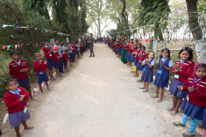 Schoolchildren line up to receive Thaye Dorje, His Holiness the 17th Gyalwa Karmapa, at the Bodhi Tree school