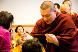 Thaye Dorje, His Holiness the 17th Gyalwa Karmapa, gives a blessing string to a student