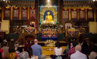 Thaye Dorje, His Holiness the 17th Gyalwa Karmapa, teaching at the KIBI Public Course, with a photograph of his late teacher His Holiness the 14th Kunzig Shamar Rinpoche on the throne