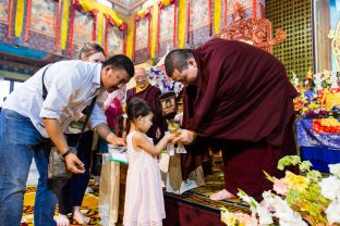 Thaye Dorje, His Holiness the 17th Gyalwa Karmapa blesses a child during the Chenresig empowerment at the KIBI Public Course