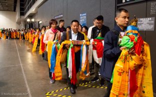 Devotees hold symbolic offerings of enlightened body, speech and mind as they queue for a blessing from Thaye Dorje, His Holiness the 17th Gyalwa Karmapa