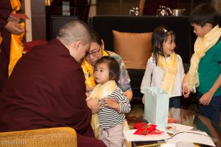 A small child is blessed by Thaye Dorje, His Holiness the 17th Gyalwa Karmapa