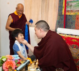 Students and visitors make symbolic offerings and receive blessings at the Bodhi Path Tara Buddhist Centre of Lama Jakarla in Hong Kong. Solponla, Karmapa's senior attendant, smiles in the background