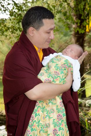 Thaye Dorje, His Holiness the 17th Gyalwa Karmapa, gently cradles Thugsey (his son)