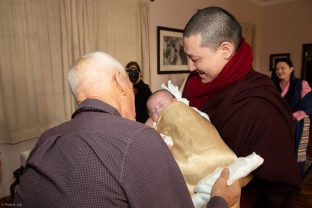 Karmapa holds Thugsey, with Lama Ole looking on affectionately. Sangyumla Rinchen Yangzom is in the background.