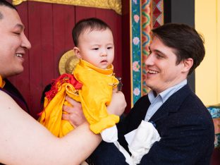 Thaye Dorje, His Holiness the 17th Gyalwa Karmapa, and Trinlay Rinpoche, hold baby Thugsey together