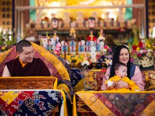 Thaye Dorje, His Holiness the 17th Gyalwa Karmapa, looks affectionately at Thugsey during the final day of the Karmapa Public Course. Baby Thugsey sits calmly on Sangyumla's lap.