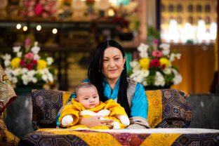 Sangyumla Rinchen Yangzom tenderly holds little Thugsey in the temple at KIBI.