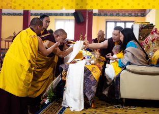 Everyone present at the Public Meditation Course lined up to offer a white scarf (khata) to Karmapa, and then to Thugsey (held by Sangyumla)