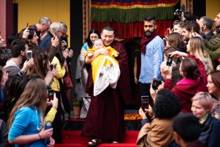 The students capture a special moment as Karmapa gently carries his son at KIBI. Sangyumla follows closely behind