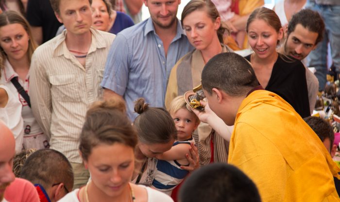 Thaye Dorje, His Holiness the 17th Gyalwa Karmapa, blesses a mother and child at a Dharma course. Photo / Magda Jungowska