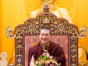 Thaye Dorje, His Holiness the 17th Gyalwa Karmapa, in front of a statue of the Buddha