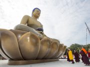 Thaye Dorje, His Holiness the 17th Gyalwa Karmapa, offers a silk scarf to the statue of Amitabha Buddha. Photo / Thule Jug