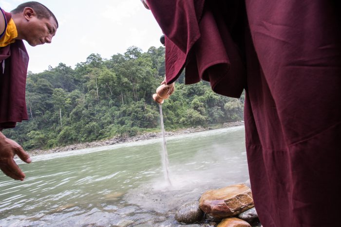 Pouring a mandala offering into the river on the 3rd anniversary of the parinirvana of His Holiness Kunzig Shamar Rinpoche. Photo / Magda Jungowska